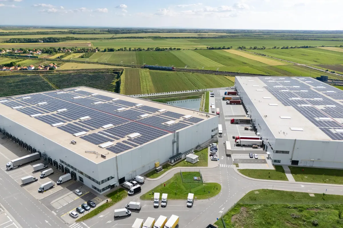 Bovenaanzicht van een groot industrieel bedrijfsdak volledig bedekt met zonnepanelen — typisch voorbeeld van een grootverbruiker die stroom teruglevert aan het net en netcongestie ervaart